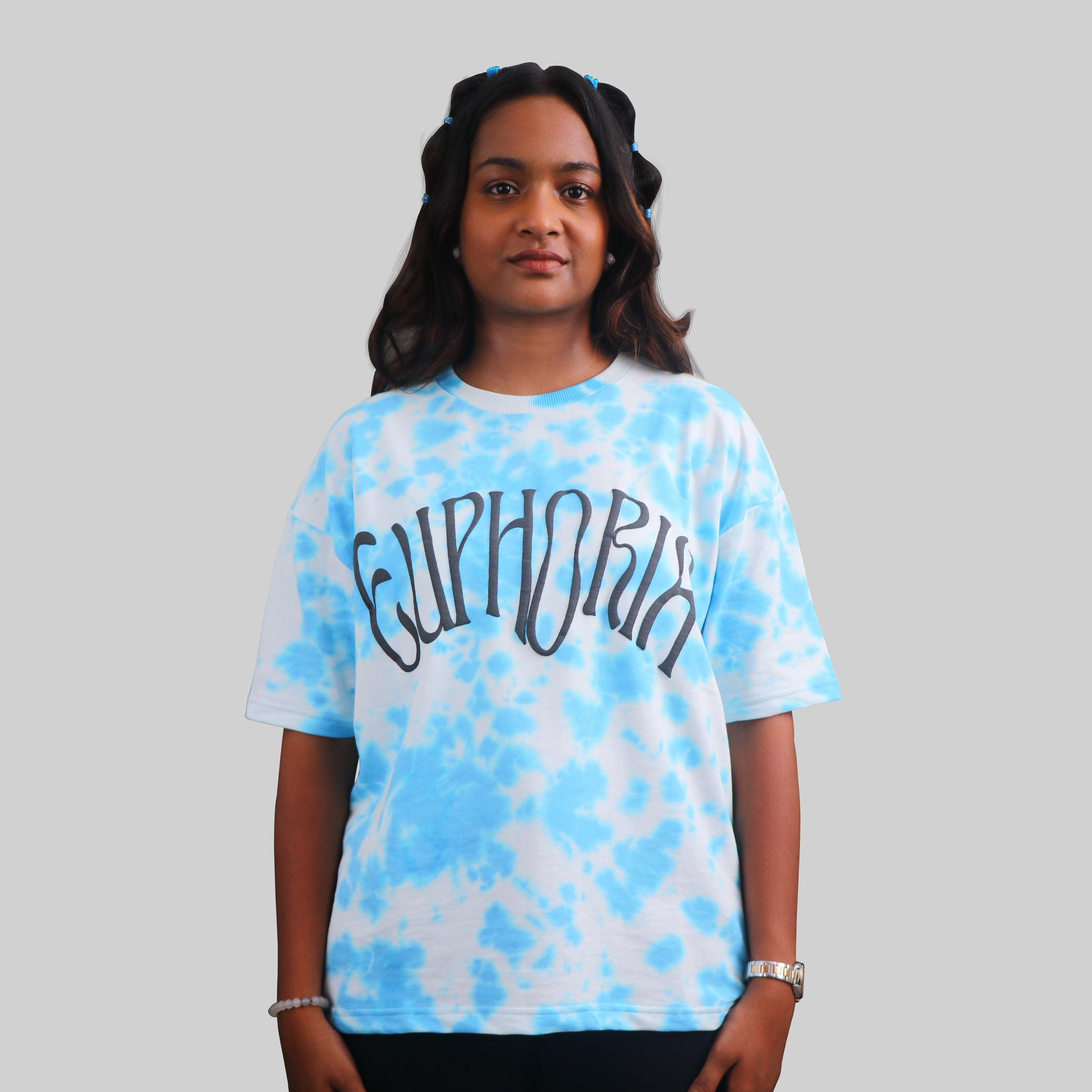 A woman wearing a blue tie-dye oversized T-shirt with the word 'CUPHORN' printed on the front.
