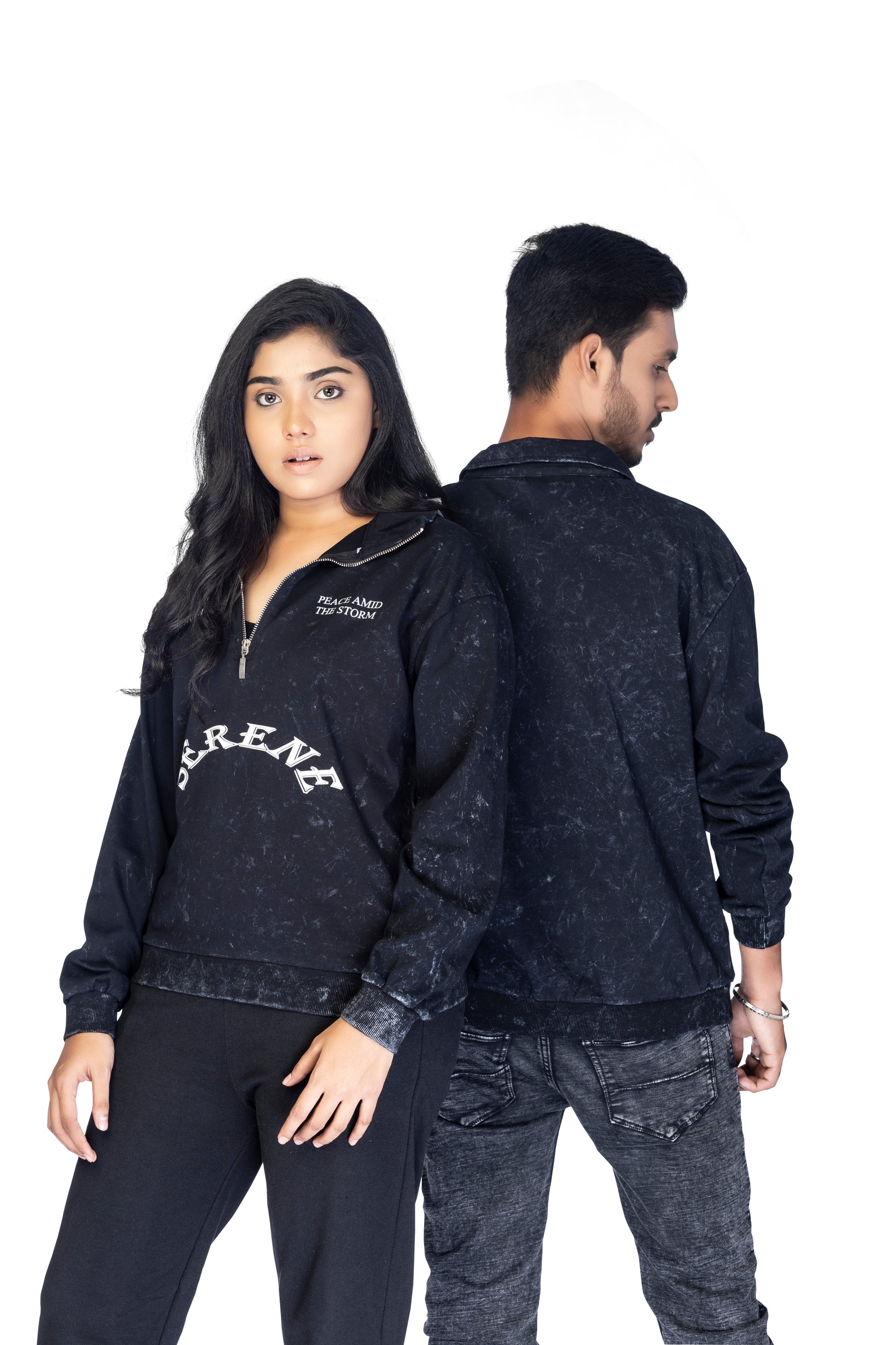 Two people wearing matching black distressed jackets with visible branding.