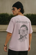 Person wearing a t-shirt with a graphic design and text outdoors.