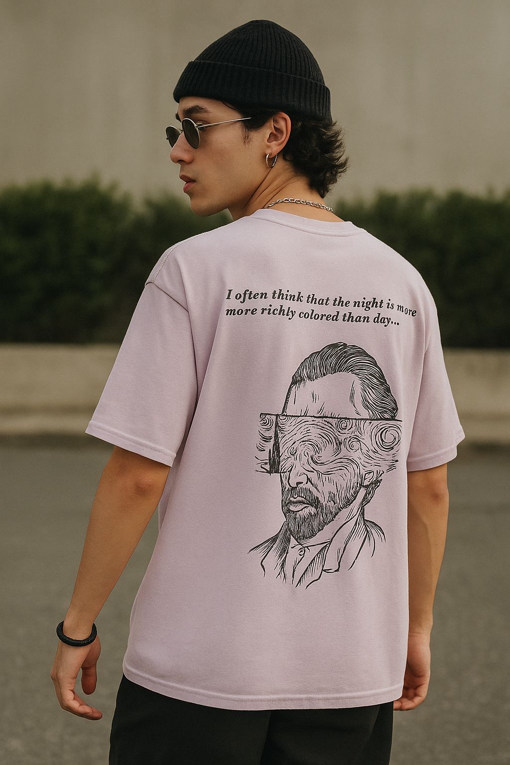 Person wearing a t-shirt with a graphic design and text outdoors.