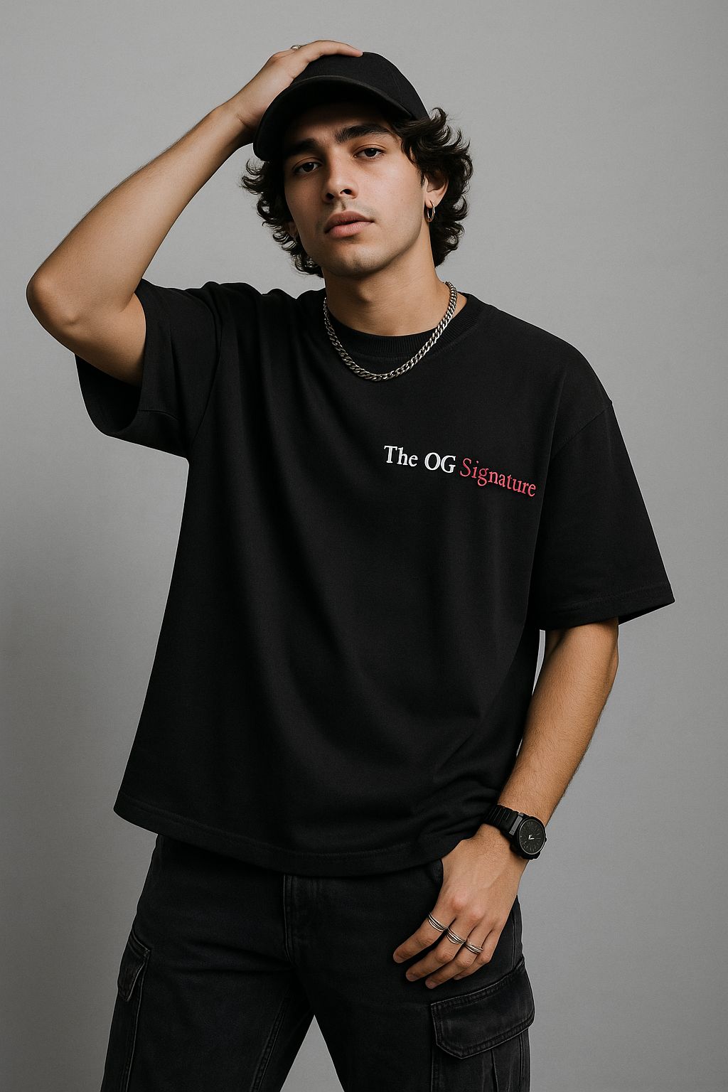 Person wearing a black t-shirt with text, standing against a gray background