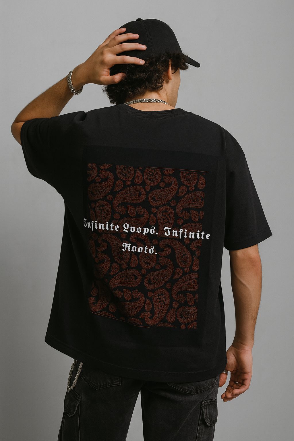 Person wearing a black t-shirt with text and graphics on the back against a gray background
