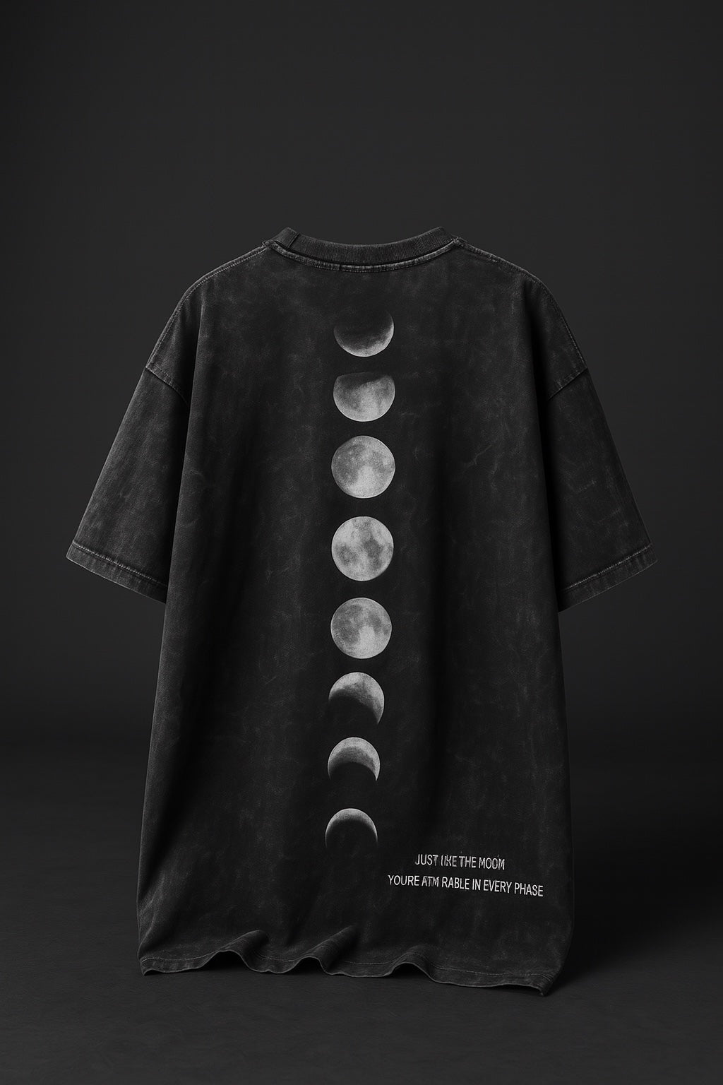 Black t-shirt with moon phase design on a dark background