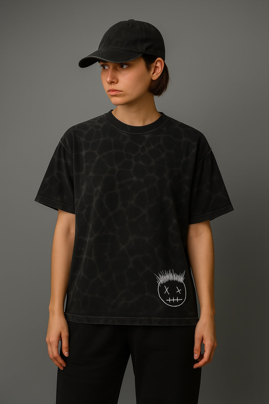 Person wearing a black t-shirt with a small graphic on a gray background