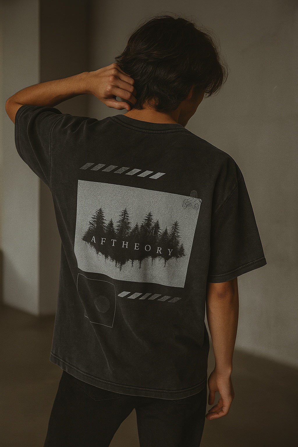 Person wearing a black t-shirt with a graphic design on the back against a plain background