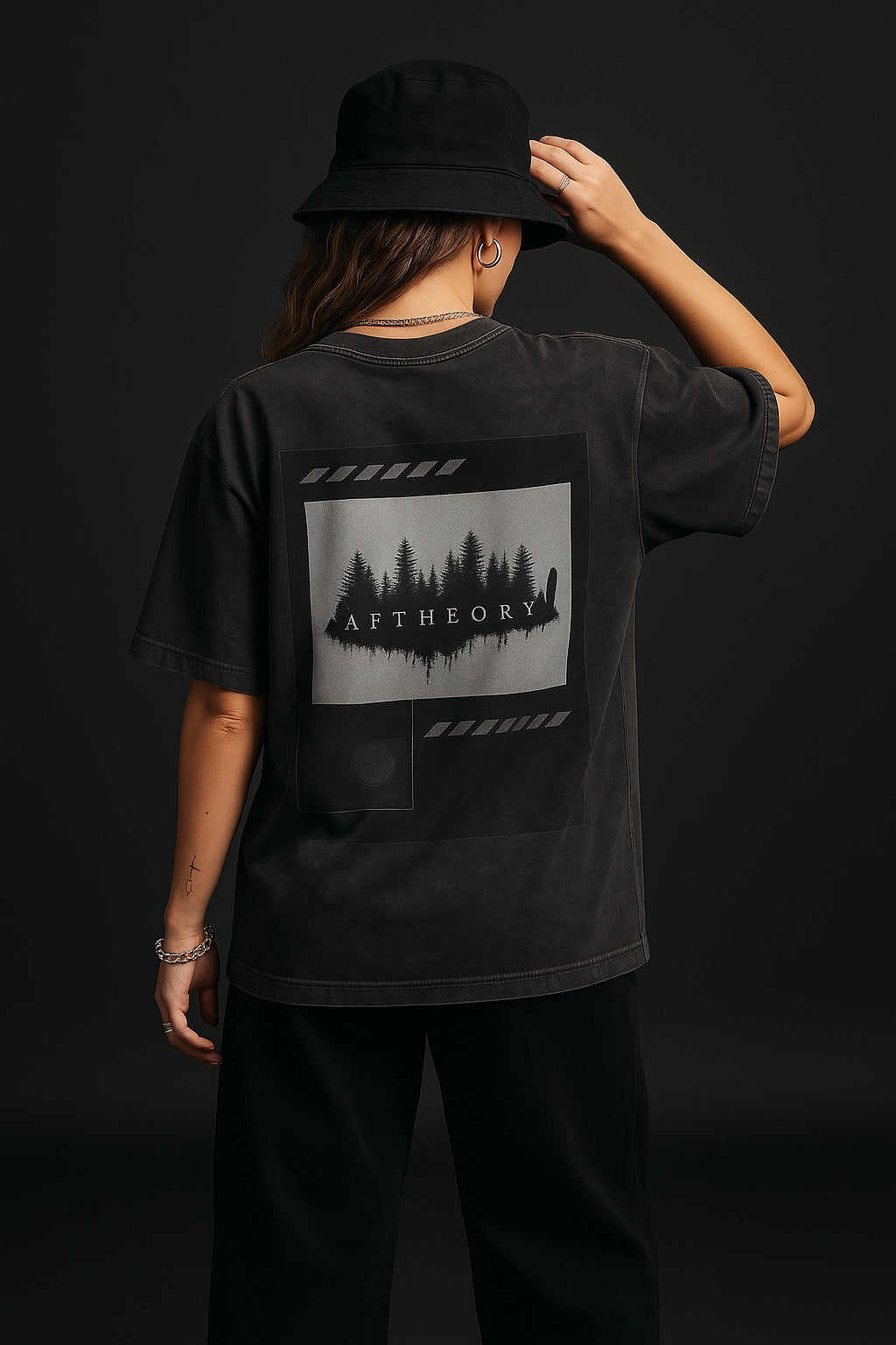 Person wearing a black t-shirt with 'AFTHEORY' design on the back against a dark background