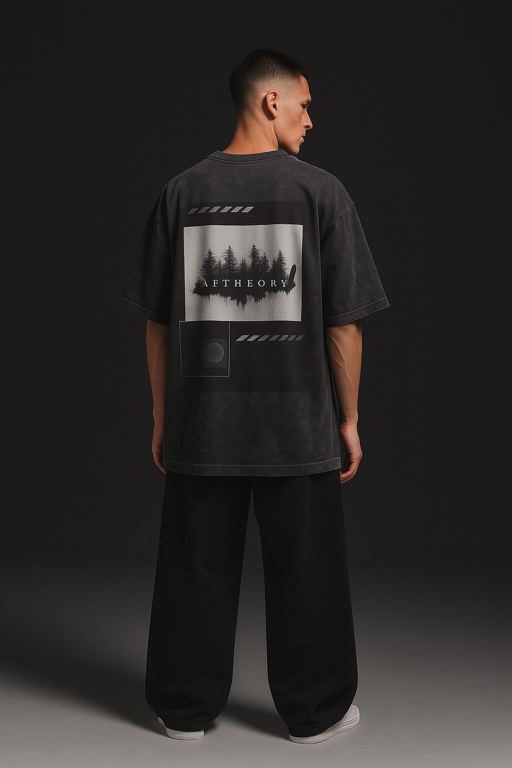 Person wearing a black t-shirt with a graphic design on the back against a dark background